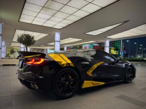Black Chevrolet Corvette C8 with gold wrap accents in Dubai
