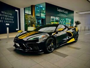 Black Chevrolet Corvette C8 with gold wrap accents in Dubai