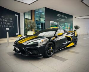 Black Chevrolet Corvette C8 with gold wrap accents in Dubai
