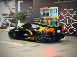 Black Chevrolet Corvette C8 with gold wrap accents in Dubai