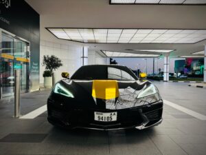 Black Chevrolet Corvette C8 with gold wrap accents in Dubai