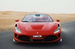 Luxury Ferrari F8 Tributo 2024 red convertible parked in Dubai desert with sporty design and V8 performance
