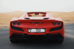 Luxury Ferrari F8 Tributo 2024 red convertible parked in Dubai desert with sporty design and V8 performance