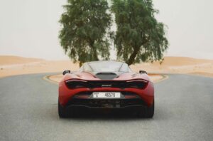 Red McLaren 720S 2024 with butterfly doors open in desert road