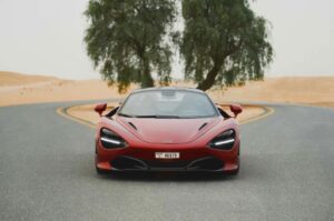 Red McLaren 720S 2024 with butterfly doors open in desert road
