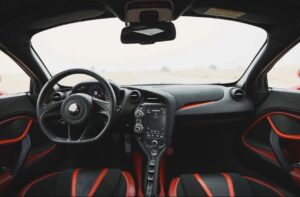 Red McLaren 720S 2024 with butterfly doors open in desert road