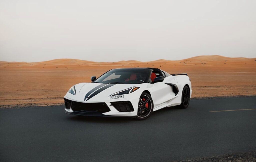 White Chevrolet Corvette C8 with black racing stripe in Dubai desert