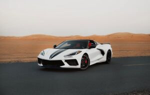 White Chevrolet Corvette C8 with black racing stripe in Dubai desert