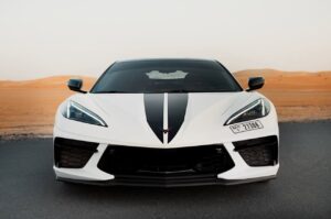 White Chevrolet Corvette C8 with black racing stripe in Dubai desert