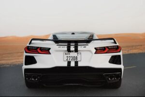 White Chevrolet Corvette C8 with black racing stripe in Dubai desert