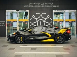 Black Chevrolet Corvette C8 with gold wrap accents in Dubai