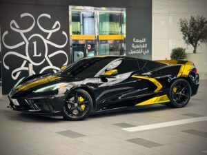 Black Chevrolet Corvette C8 with gold wrap accents in Dubai